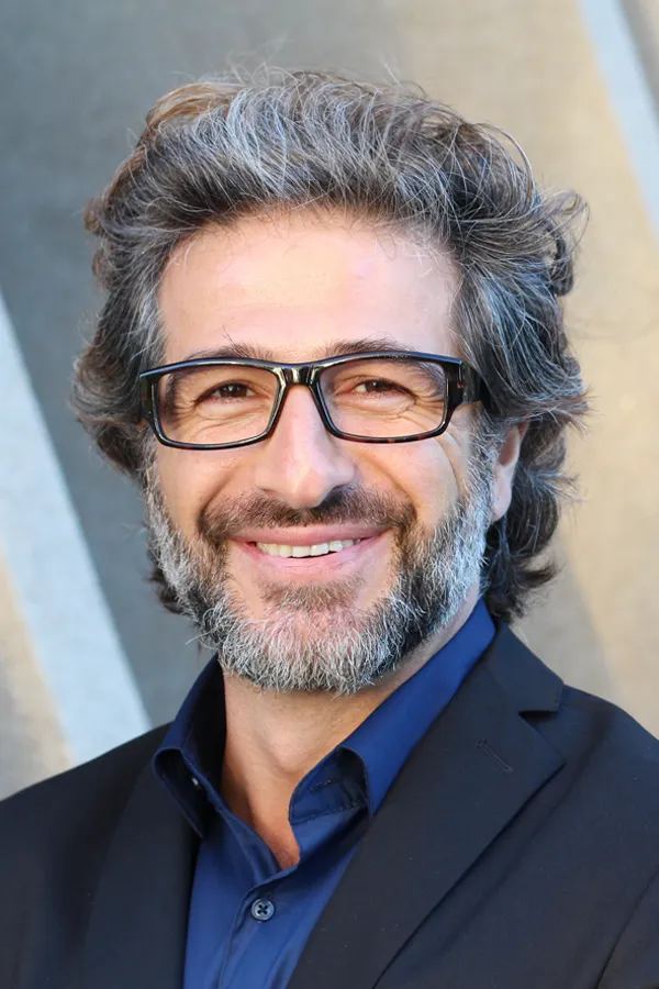 Andropause-and-Low-Testosterone-Treatment A man with glasses, salt and pepper hair and a beard smiling because he received treatment for andropause and low testosterone from Anita Petruzzelli, M.D. in Glastonbury.