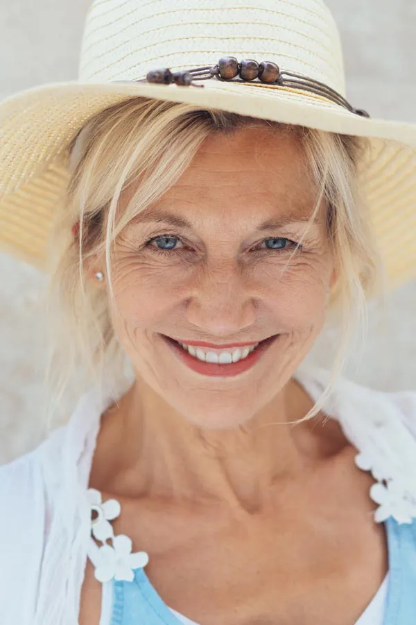 Menopause-Treatment A beautiful, smiling older woman with blonde hair and a sunhat, happy with menopause treatment from Anita Petruzzelli, M.D. in Glastonbury.
