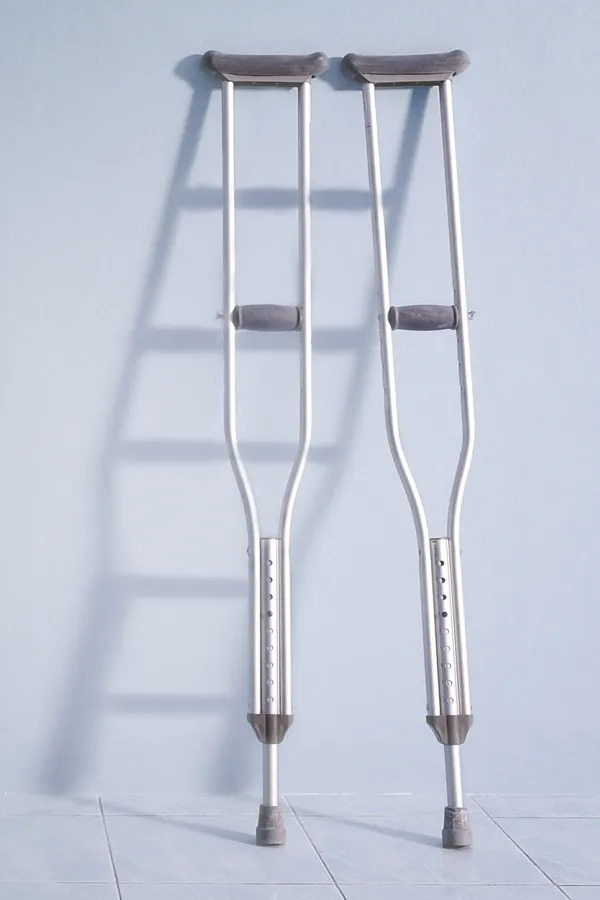 Peptides-for-Healing-and-Recovery-Treatment A pair of crutches rest against a gray wall, representing peptide therapy for healing and recovery from Anita Petruzzelli, M.D. in Glastonbury.