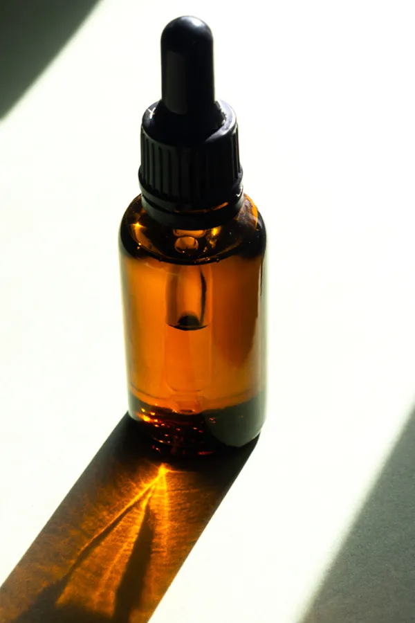 Performance-Enhancing-Peptides-Treatment A brown dropper bottle on a table lit by sunlight, representing performance enhancing peptide treatment from Anita Petruzzelli, M.D. in Glastonbury.