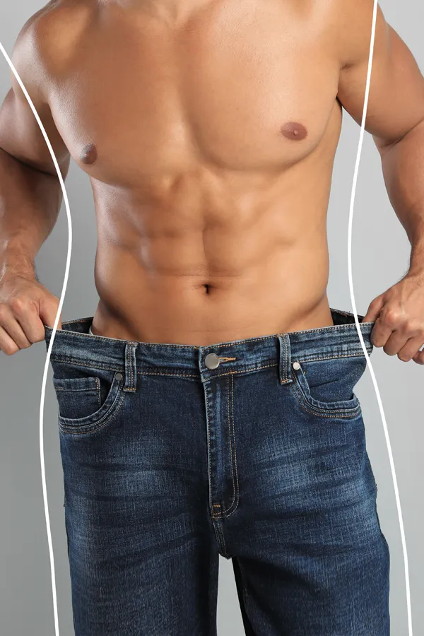 Semaglutide-Weight-Loss-Treatment A strong shirtless man in jeans holds the waistlines of his too-big jeans to show the success of semaglutide weight loss from Anita Petruzzelli, M.D. in Glastonbury.