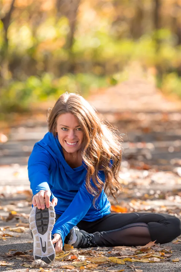 Sermorelin-Treatment A healthy woman in blue sweats stretches on a trail before a run. Get Sermorelin peptide therapy from Anita Petruzzelli, M.D. in Glastonbury.