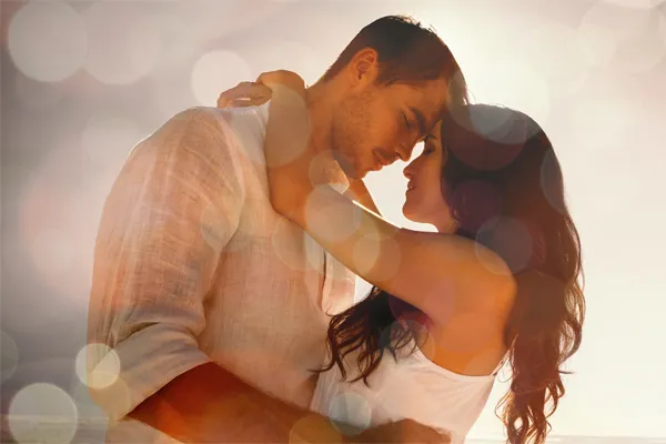 Sexual-Wellness-for-Women-and-Men-Doctor A couple in linen shirts standing in a sparkling light embraces each other with their foreheads touching and eyes closed, happy with their sexual wellness treatments from Anita Petruzzelli, M.D. in Glastonbury.